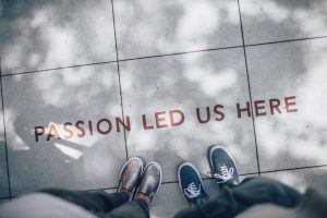 View of two people looking down at feet with words on ground